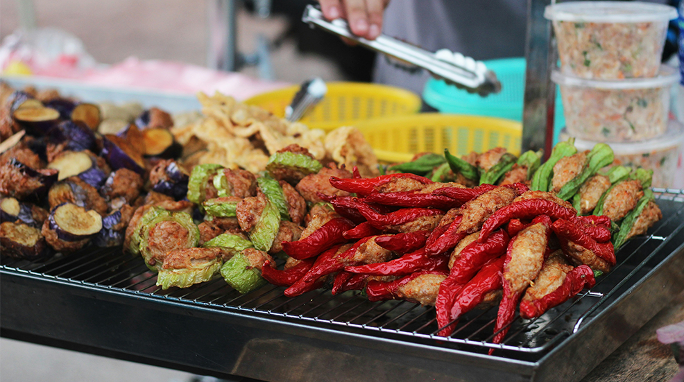 Local cuisine cooking at a food market abroad